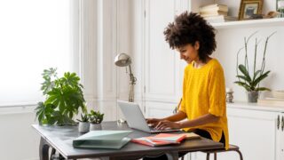 Woman sitting at desk, working, using laptop